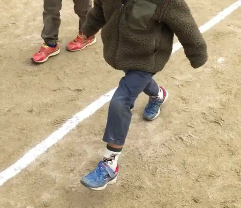 園庭でコートの真ん中を確かめる子どもたち