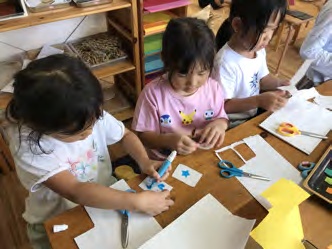 紙を切り、数字やマークを描いてトランプを作る子どもたち
