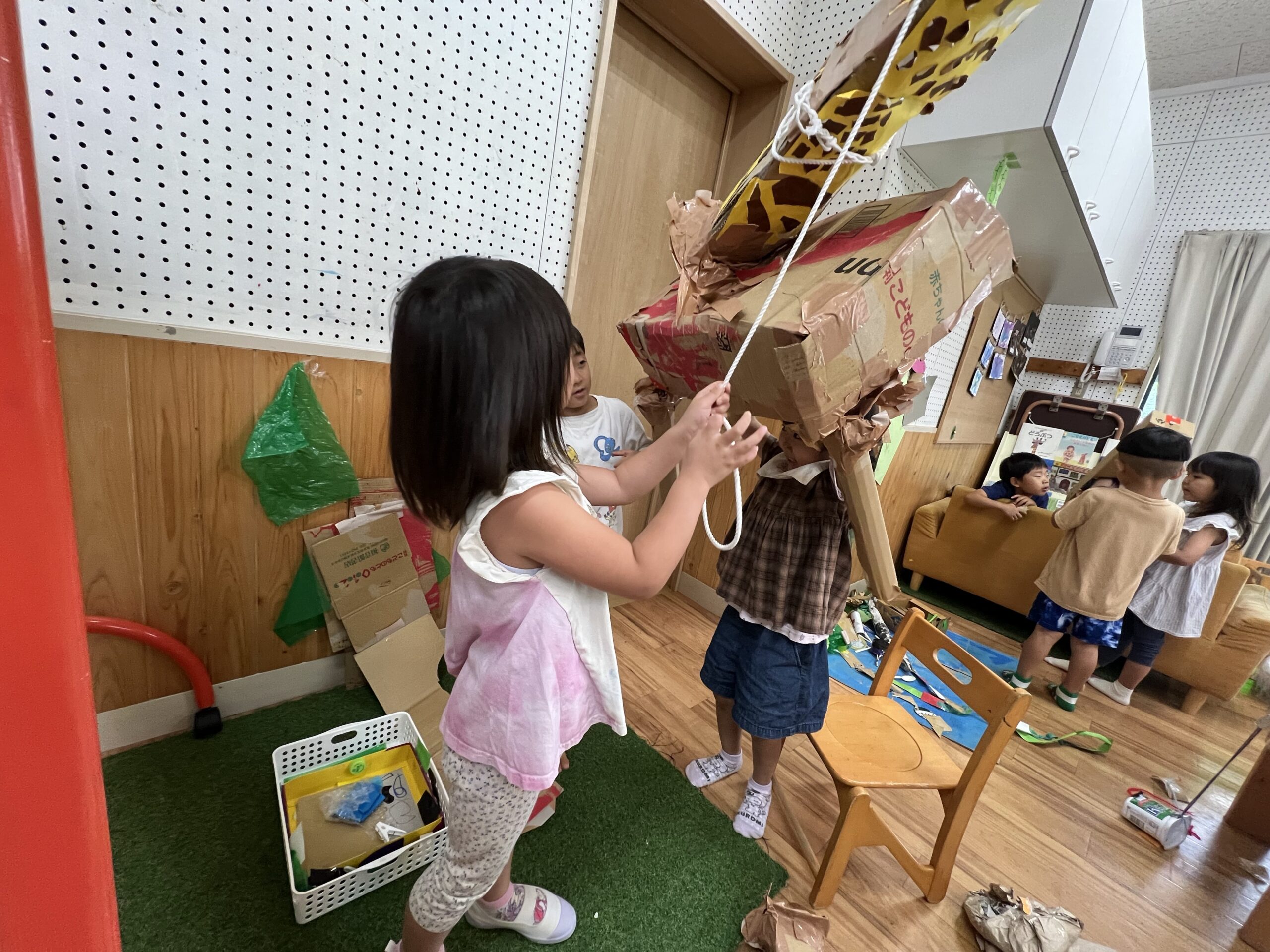 ひもと滑車を使ってキリンを吊り上げる子どもたち