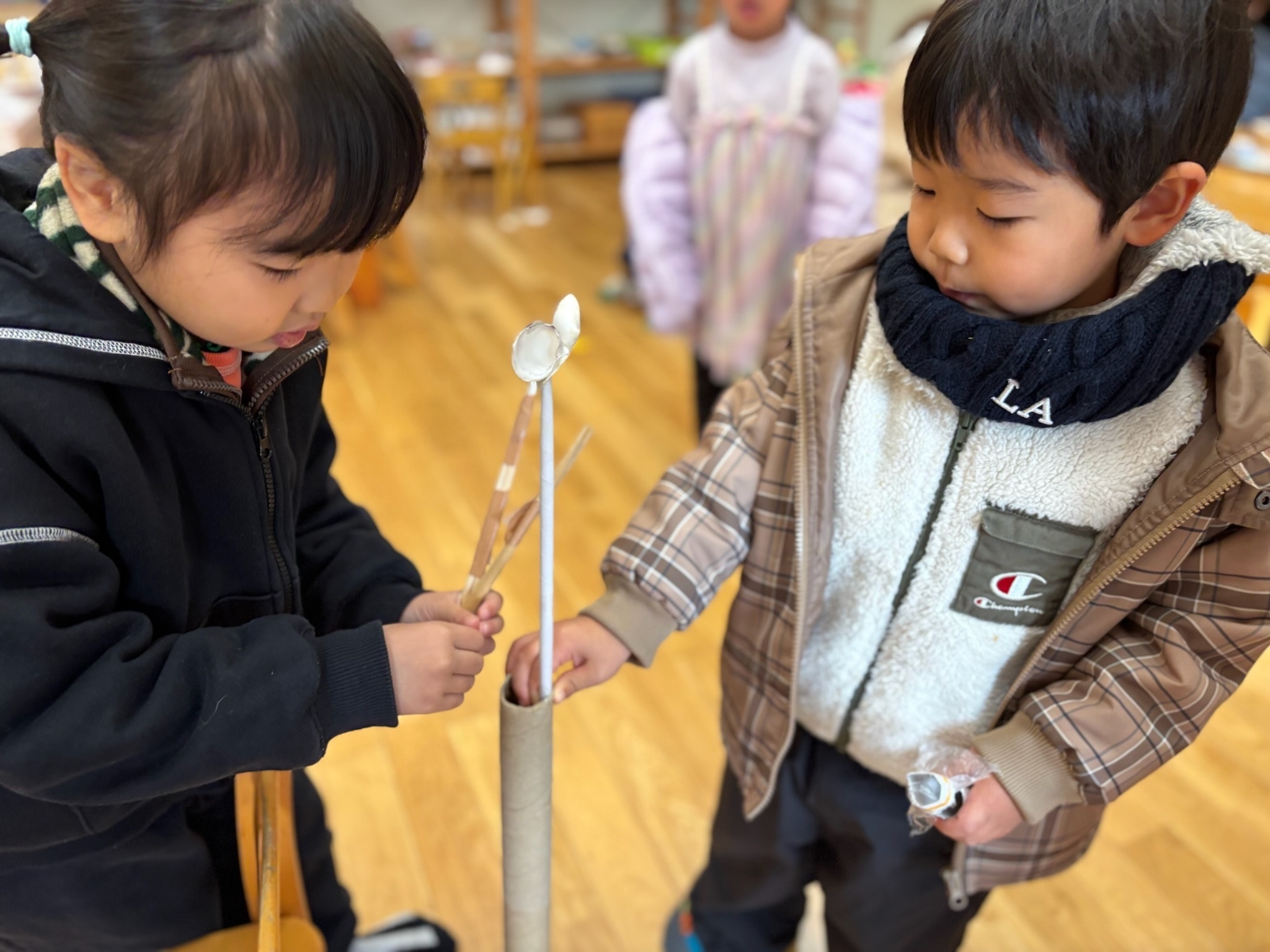貝殻を使った手作りのハイハットを試す子どもたち