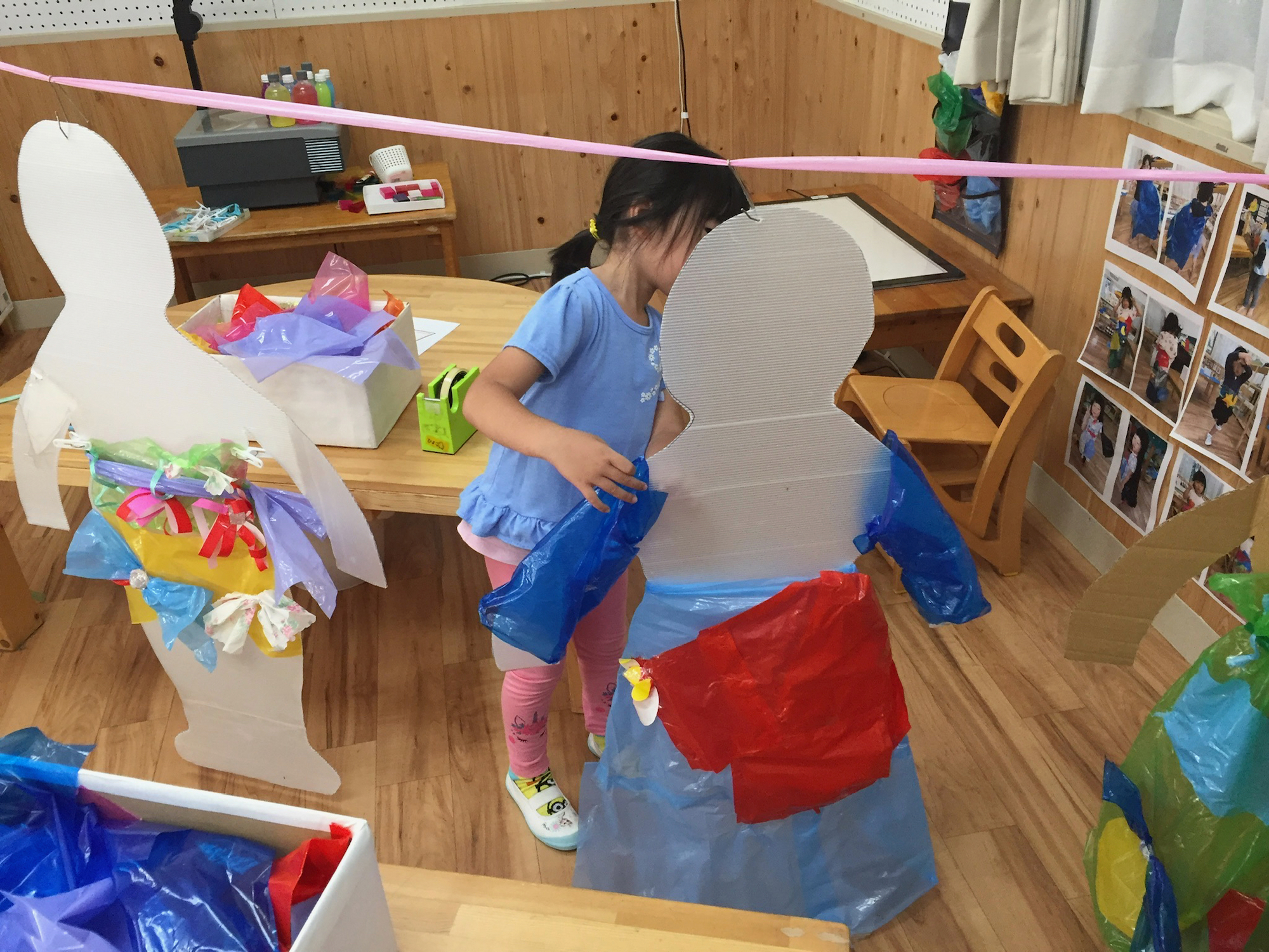 マネキンに着せた服に手を加える子ども